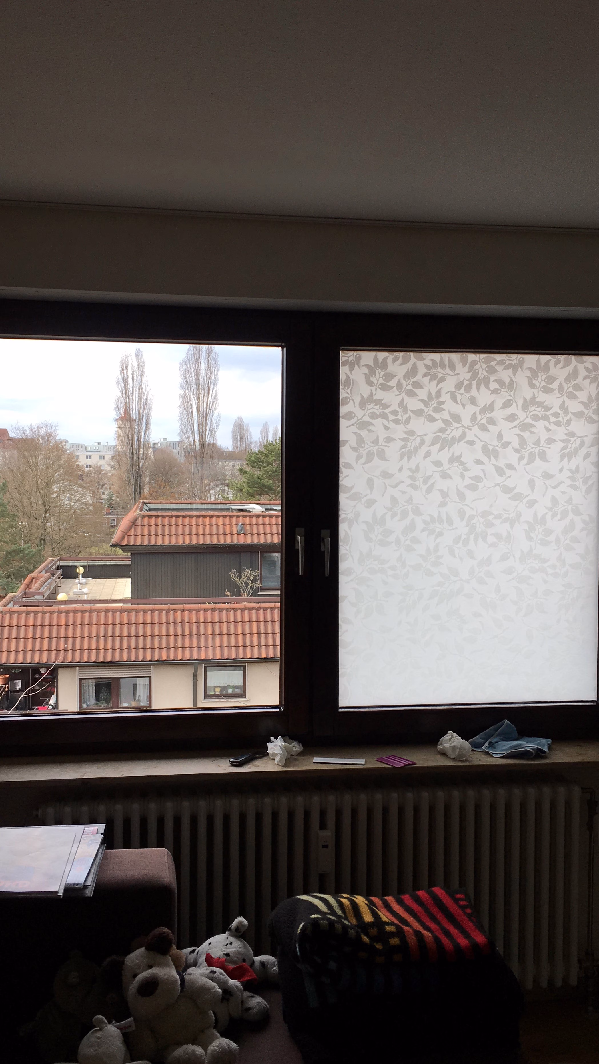 Sichtschutzfolie mit einem weißen Blätterdesign angebracht auf einem Fenster im Wohnzimmer