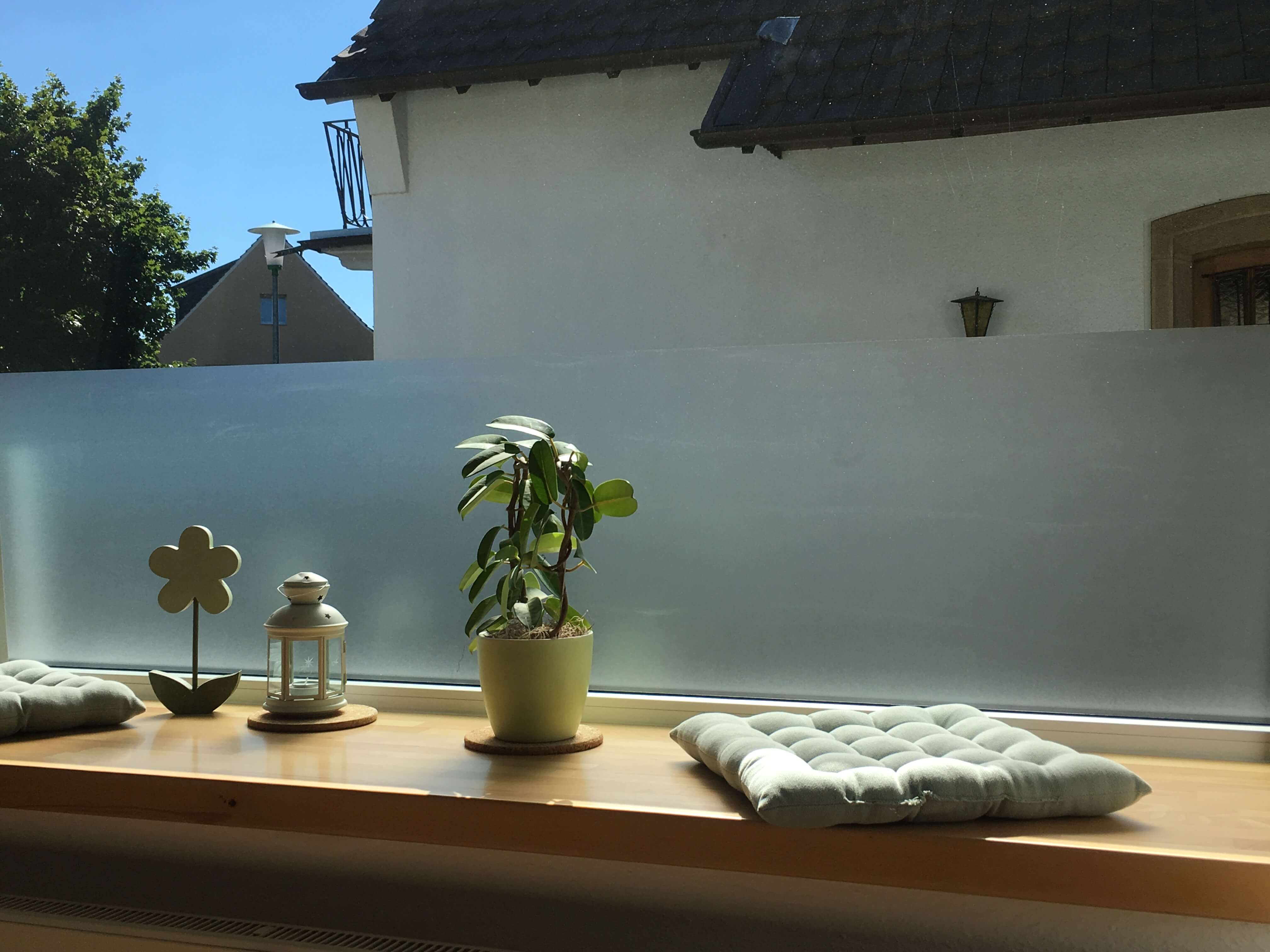 Sichtschutz als Teilbeklebung mit einer Milchglasfolie im Wohnzimmer.
