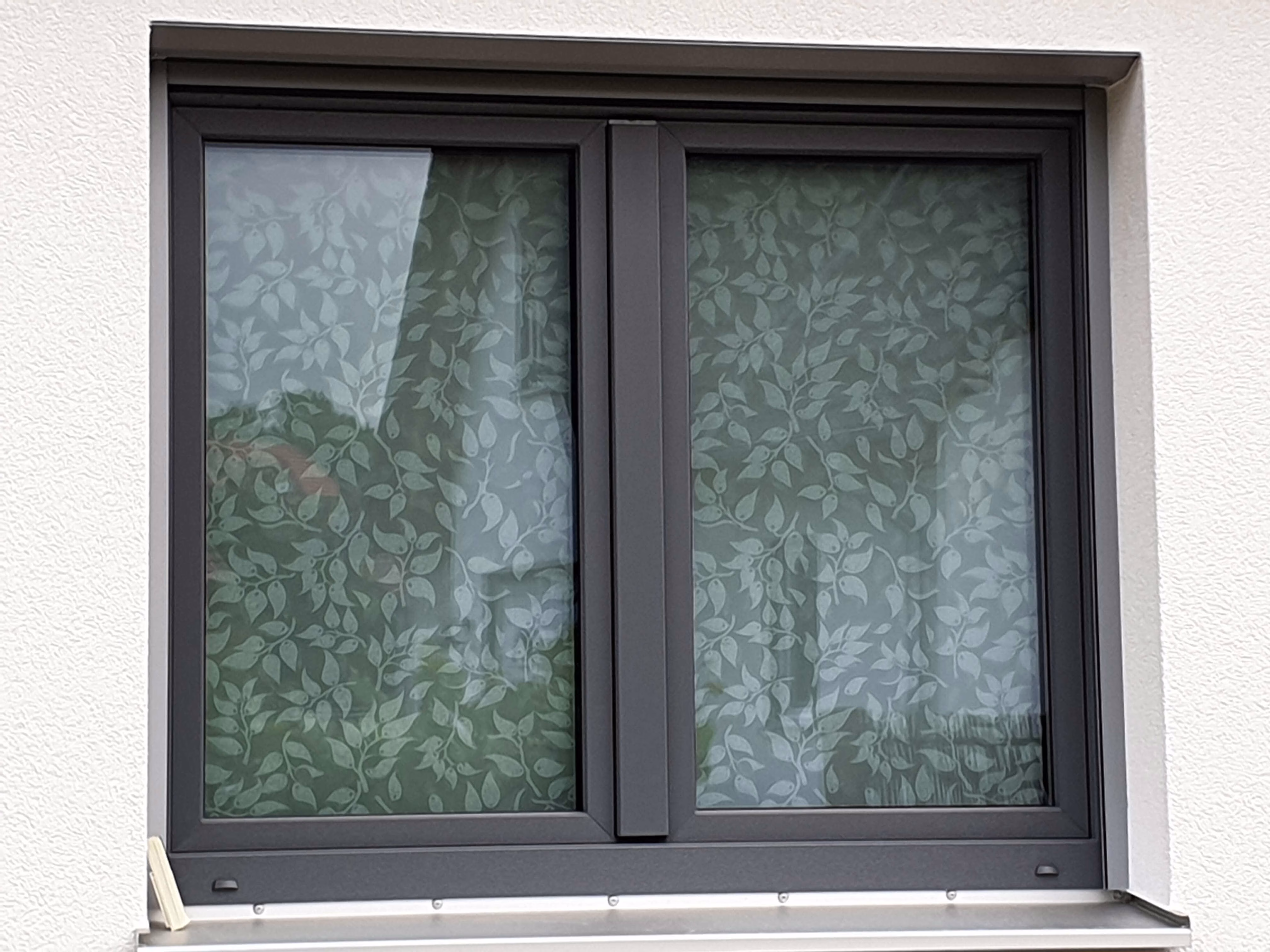 Sichtschutzfolie weiße Blätter auf weißem Grund auf einem Fenster angebracht