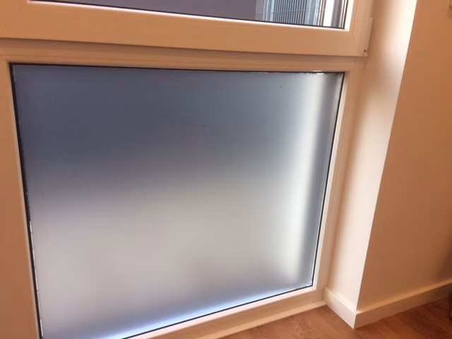 Selbsthaftende Folie auf dem unteren Teil einer Fensterfront Selbsthaftende Folie auf dem unteren Teil einer Fensterfront