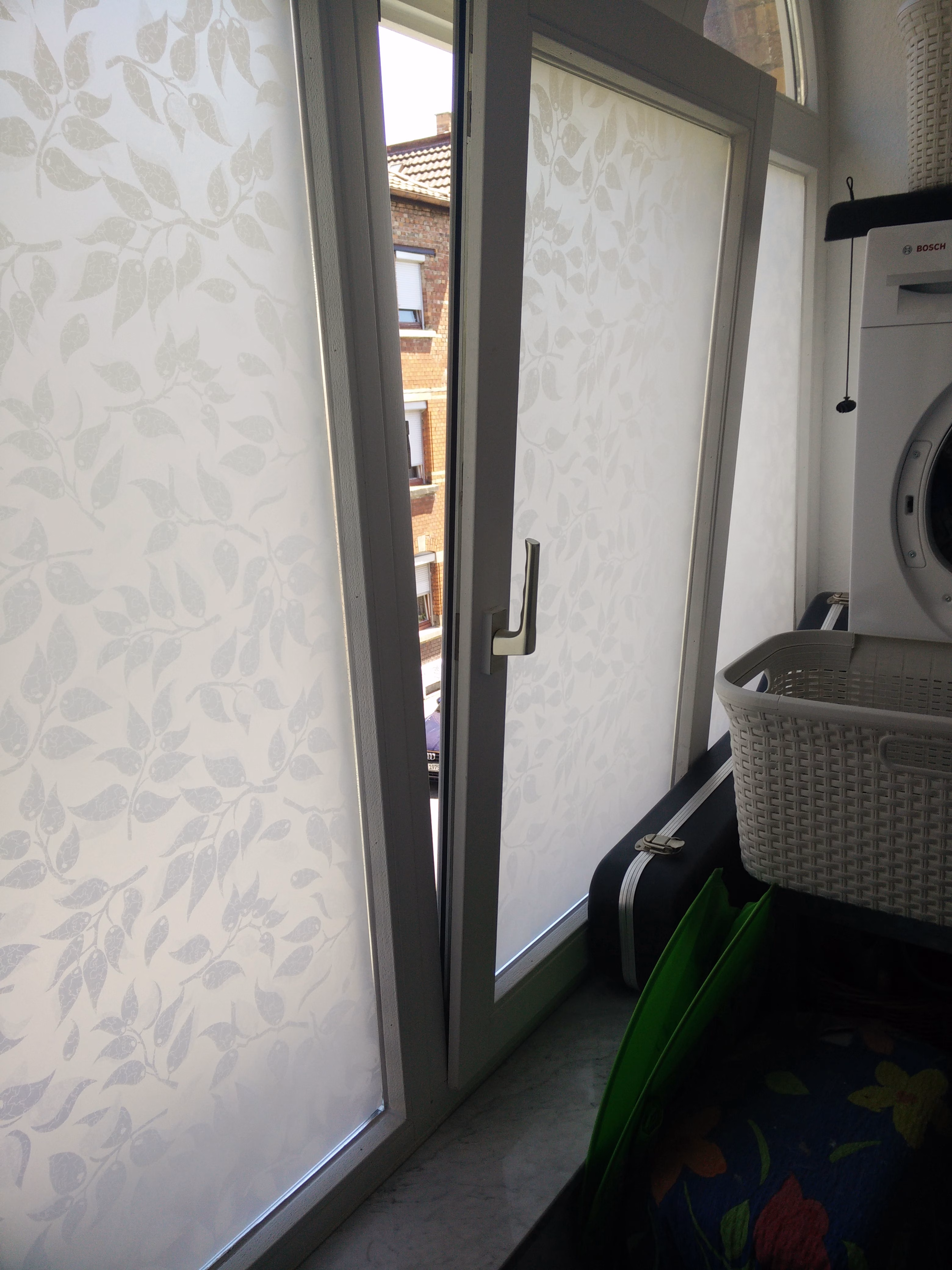 Sichtschutzfolie weiße Blätter auf weißem Grund auf einem Fenster angebracht Sichtschutzfolie weiße Blätter auf weißem Grund auf einem Fenster angebracht