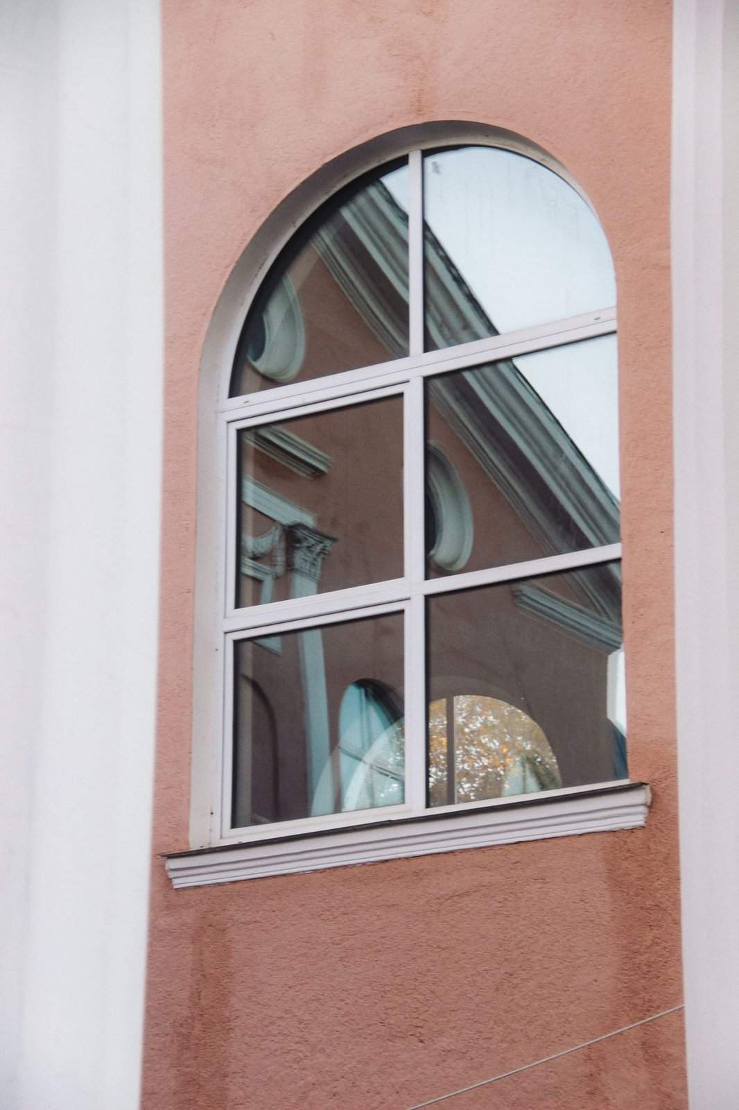 Sichtschutz am Fenster schafft mehr Privatsphäre, ohne den Tageslichteinfall vollständig zu blockieren. Fenster mit reflektierender Verglasung in einem Wohngebäude als Beispiel für Sichtschutz am Fenster
