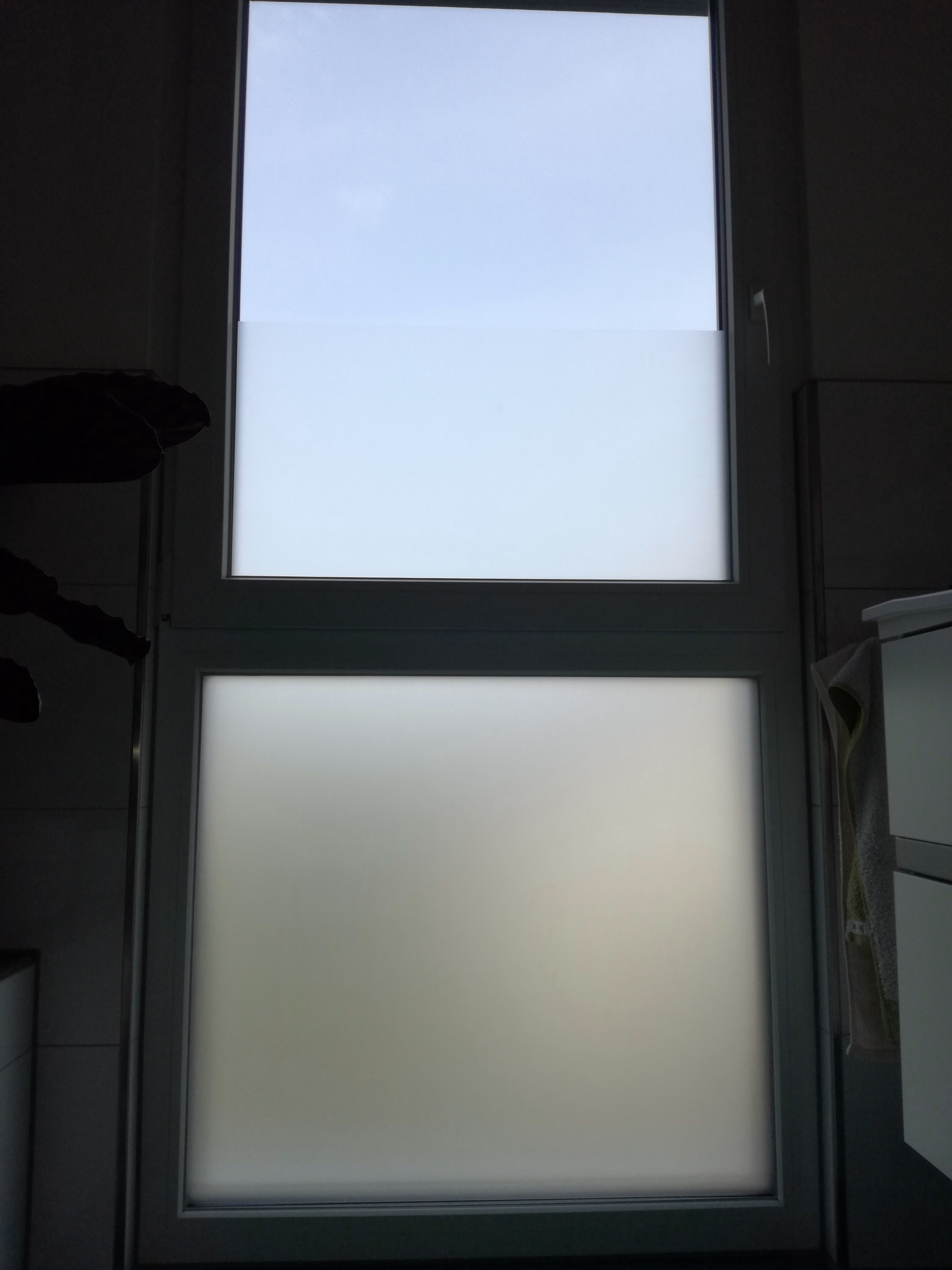 Selbsthaftende Sichtschutzfolie auf einem Badezimmerfenster angebracht. Selbsthaftende Sichtschutzfolie auf einem Badezimmerfenster angebracht.