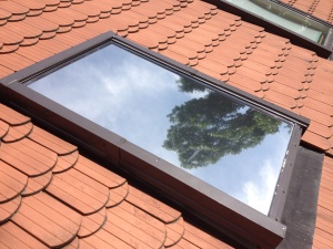 Sonnenschutzfolie silber mittel verspiegelt auf einem Dachfenster - Außenansicht