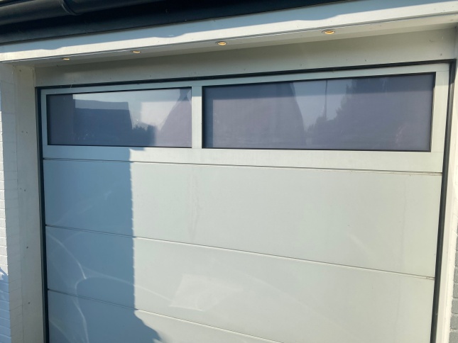 Weiß matte Sichtschutzfolie auf Fenster in einem Garagentor angebracht