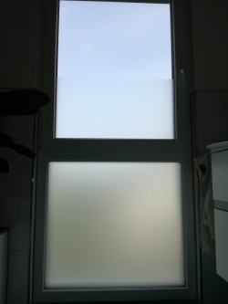 Selbsthaftende Sichtschutzfolie auf einem Badezimmerfenster angebracht.