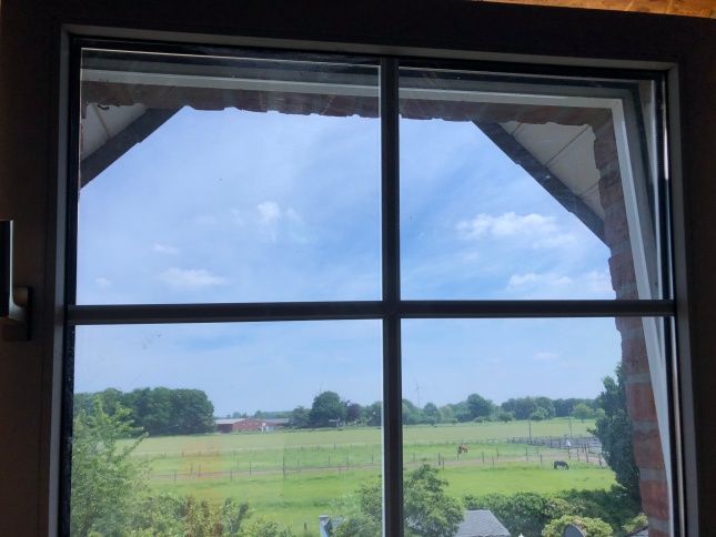 Sonnenschutzfolie silber dunkel auf einem Fenster unter dem Spitzdach