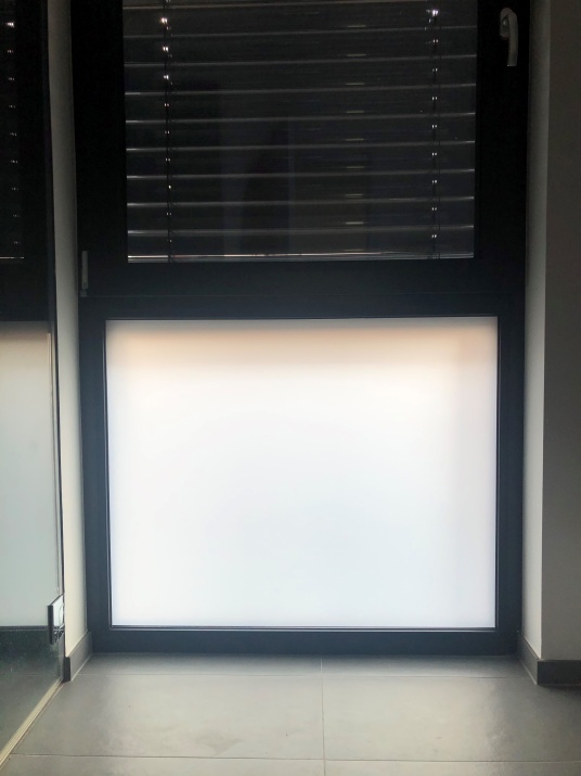 Milchige Sichtschutzfolie weiß matt auf einem Fenster.