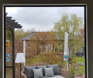 Optimal zugeschnittene und montierte Sonnenschutzfolie an einem Fenster mit Aussicht in den Garten
