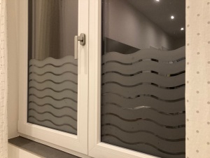 Sichtschutzfolie mit Wellenmuster auf einem Doppelfenster bei Nacht
