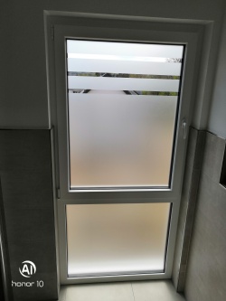 Sichtschutzfolie im Ätzglasdesign auf einem bodentiefen Fenster im Bad
