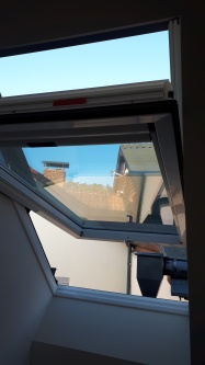 Sonnenschutzfolie als Hitzeschutz an einem geöffnetem Dachfenster