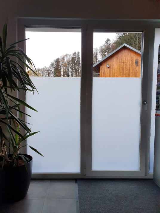 Mit Milchglasfolie teilbeklebte Fenster in einem Wohnzimmer
